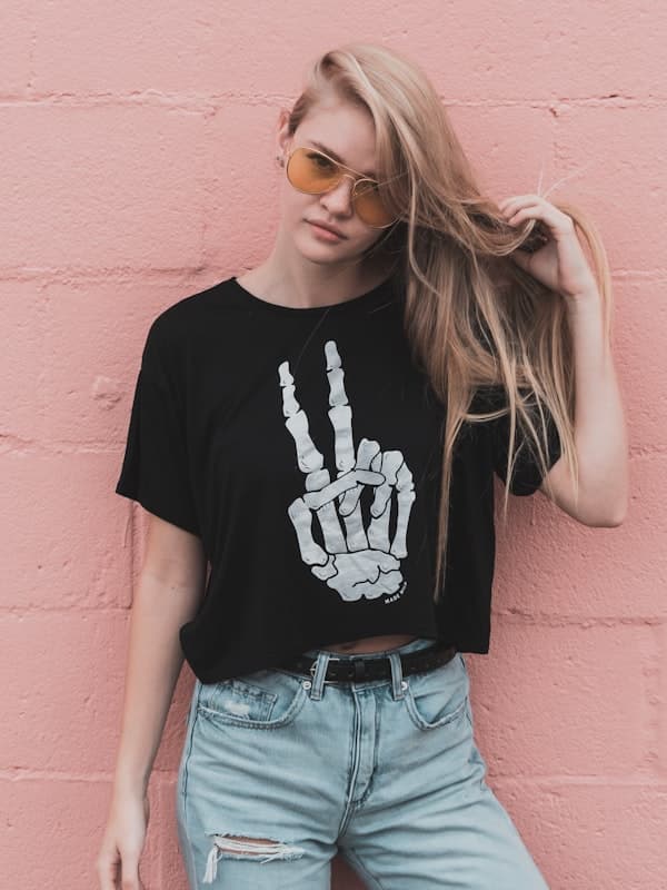 A woman in a black skeleton-hand graphic t-shirt and jeans