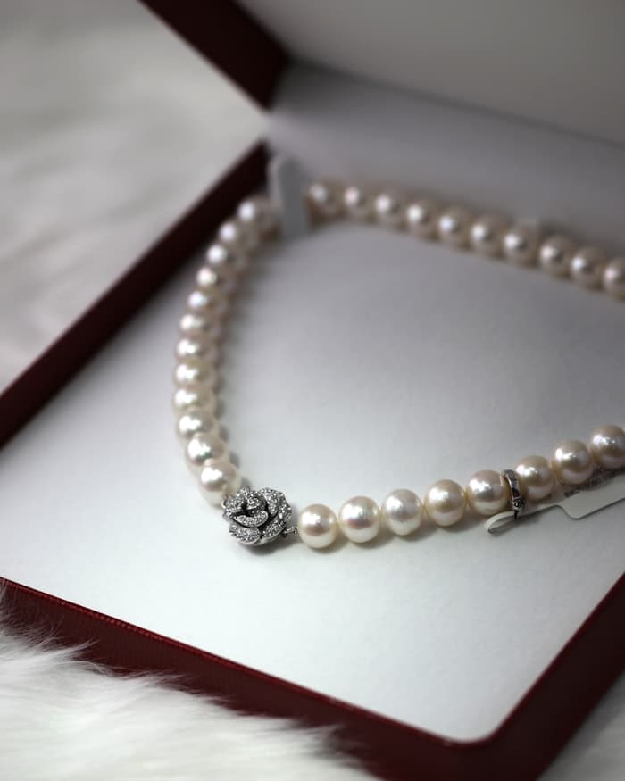 A pearl necklace resting in an open jewellery box